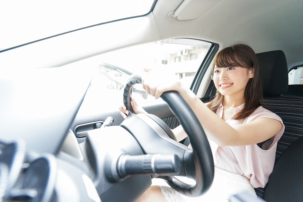 車を運転する若い日本人女性